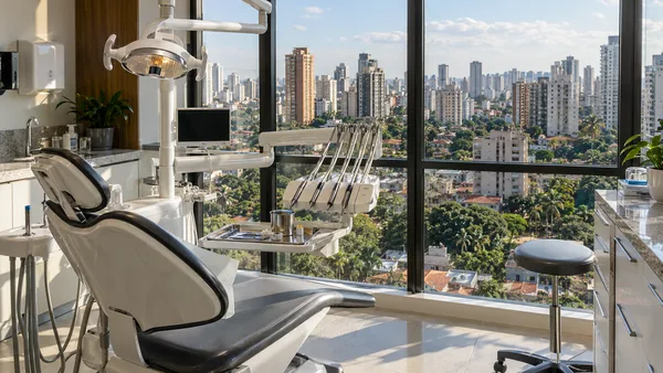 Consultório odontológico com vista para uma paisagem urbana brasileira fictícia.